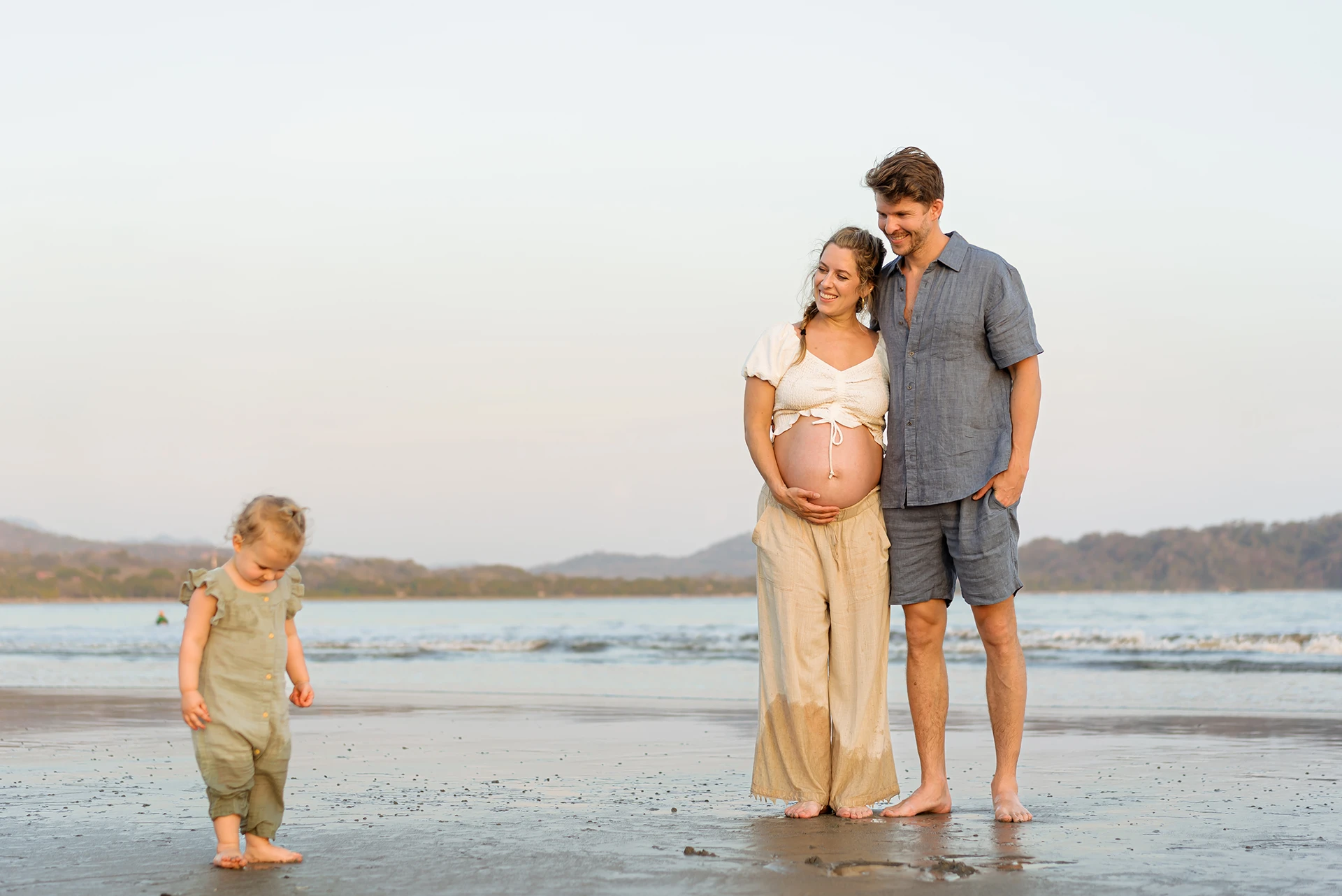 Maternity couple portrait on beach with toddler